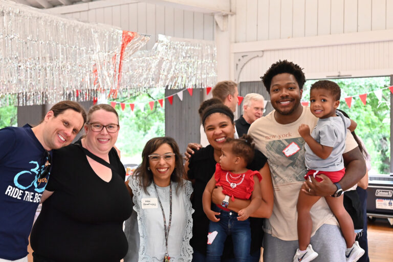 Group of fellows smiling at a picnic event