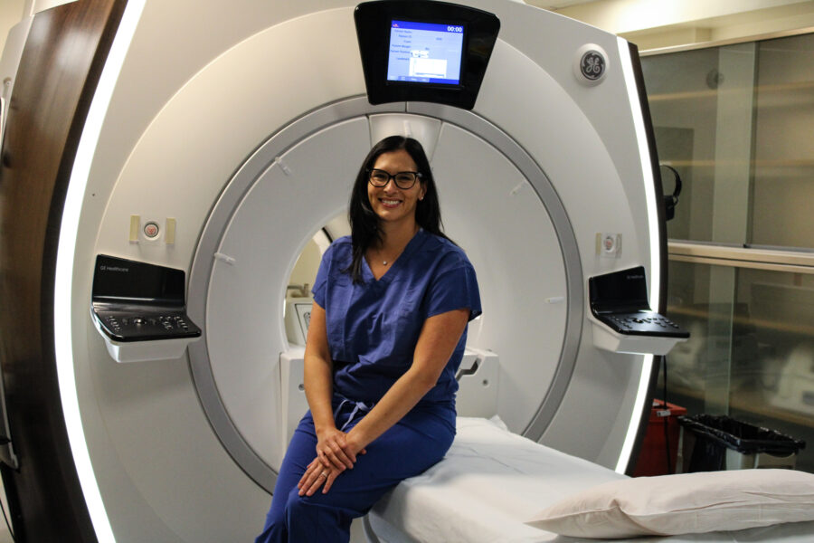 Erica Knavel sitting down on MRI machine