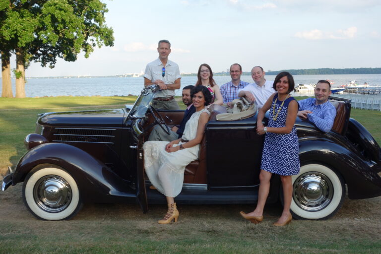 Group of fellows sitting in a vintage car celebrating a graduation