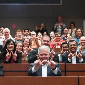 Scott Reeder and some faculty holding the "W" symbol at the Clark Radiology Symposium Square