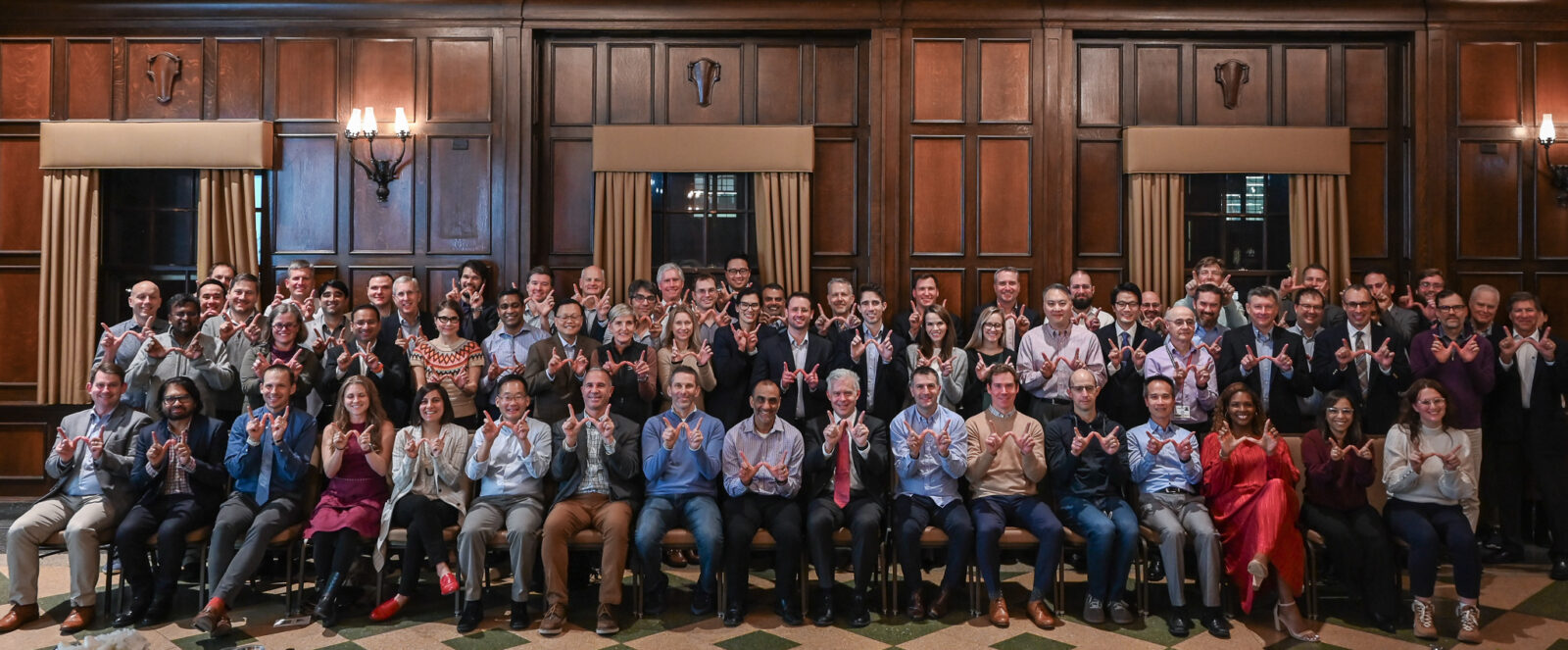 Group of faculty members holding UW-Madison's "W" symbol