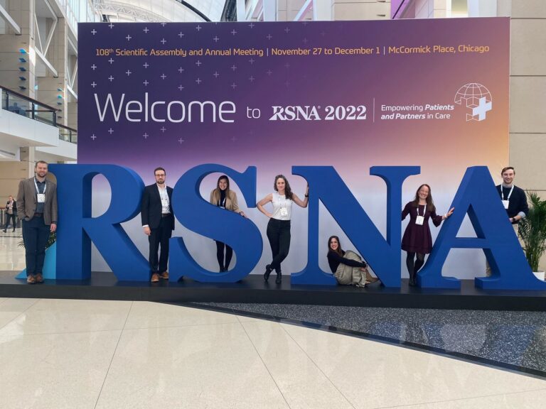 Faculty standing in front of RSNA letter blocks