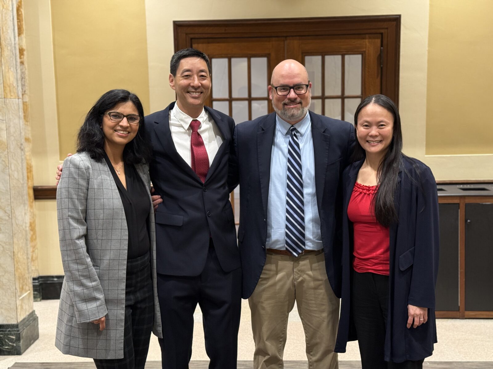 Four people pose for a group photo